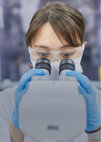 Lab technician examining a sample with a microscope